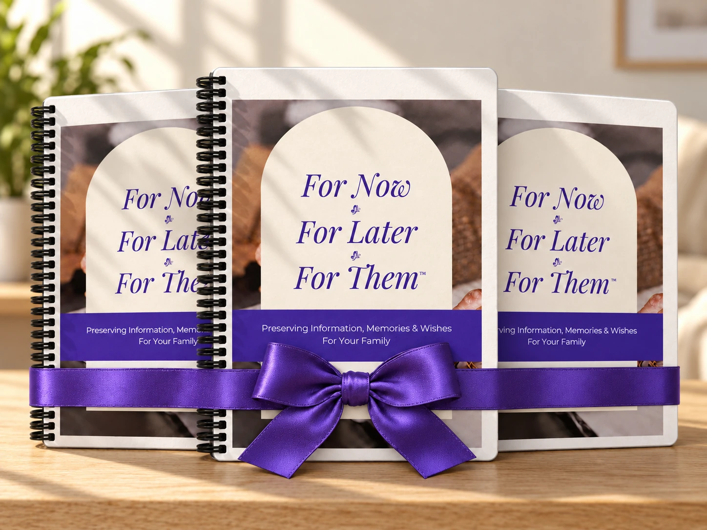 Three printed organizers tied with one large purple bow on an oak table